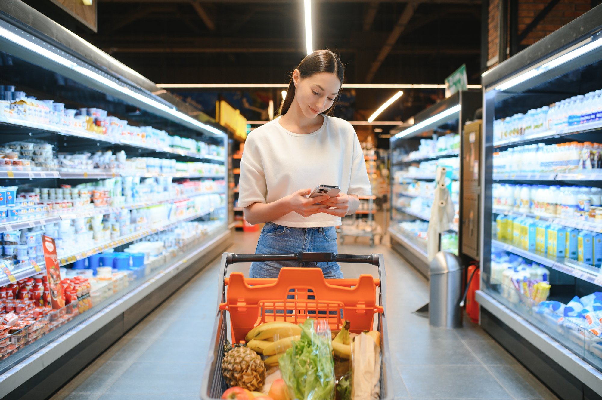 female-customer-uses-mobile-phone-in-supermarket-2024-02-01-13-57-18-utc